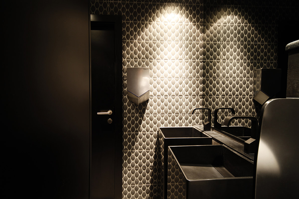 Moderni interijer toaleta u baru, s umivaonikom i ogledalom