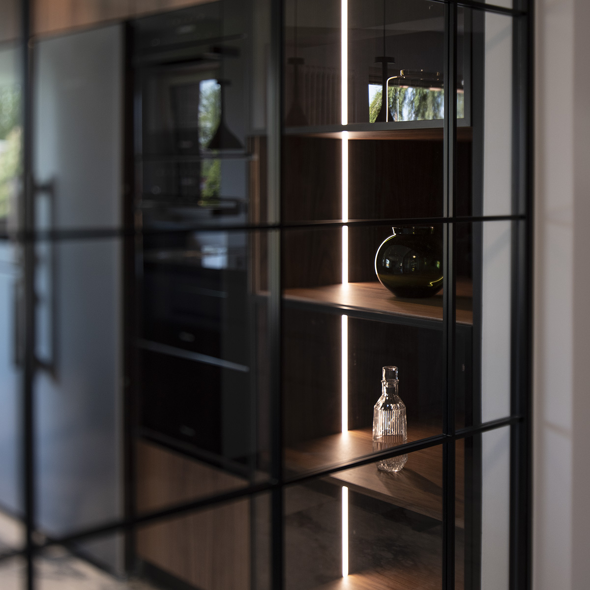 View into the kitchen through a fixed glass partition.