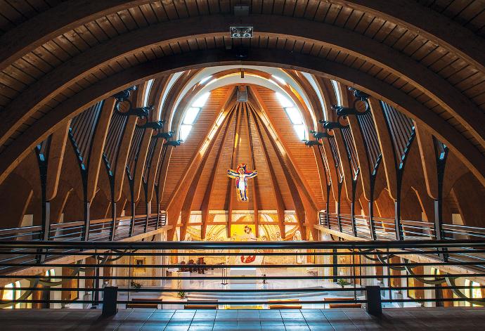 Galerija suvremene crkve s drvenim lukovima, metalnom konstrukcijom i prikazom Isusa Krista