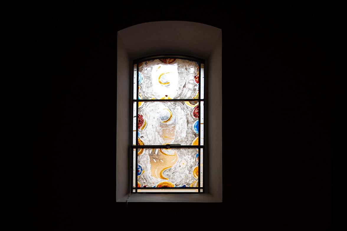 Mračna unutrašnjost s apstraktno oslikanim vitrajnim prozorom